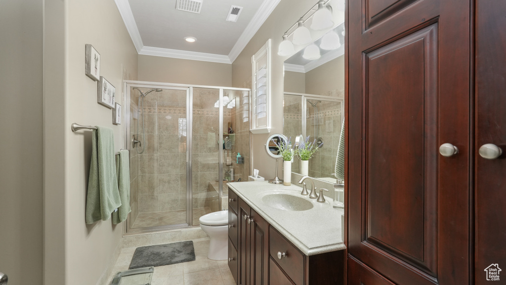 Bathroom featuring crown molding, a shower with shower door, oversized vanity, tile floors, and toilet