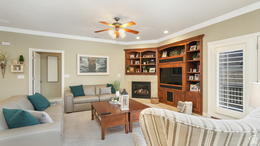 Living room with crown molding, ceiling fan, and light colored carpet