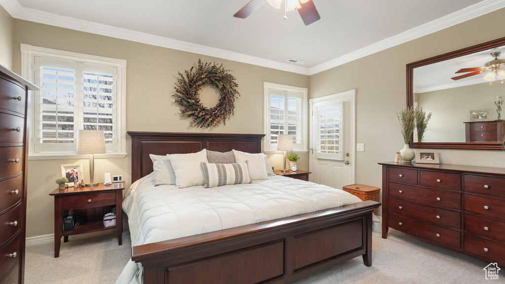 Bedroom with light carpet, ornamental molding, and ceiling fan