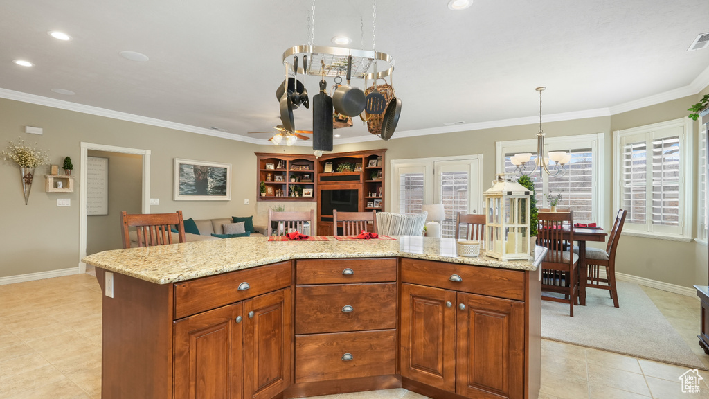 Kitchen featuring ceiling fan with notable chandelier, light stone countertops, and light tile floors