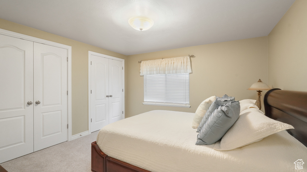 Carpeted bedroom featuring multiple closets