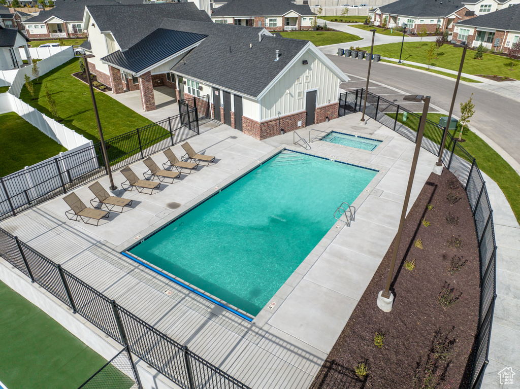 View of pool featuring a patio area, a yard, and a community hot tub