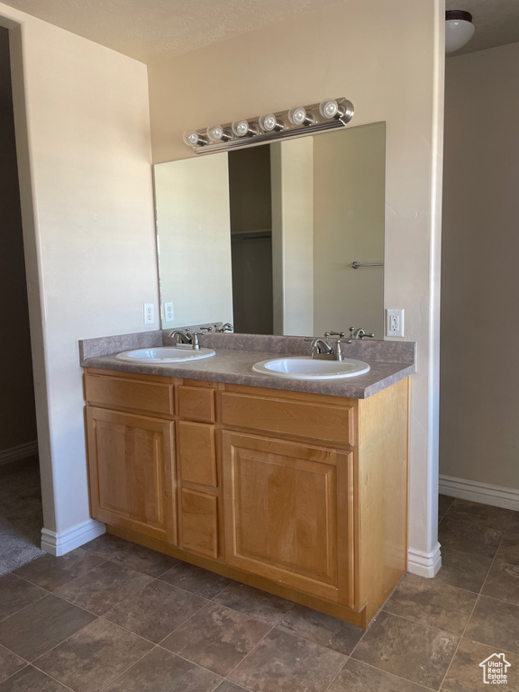 Bathroom with dual vanity and tile flooring