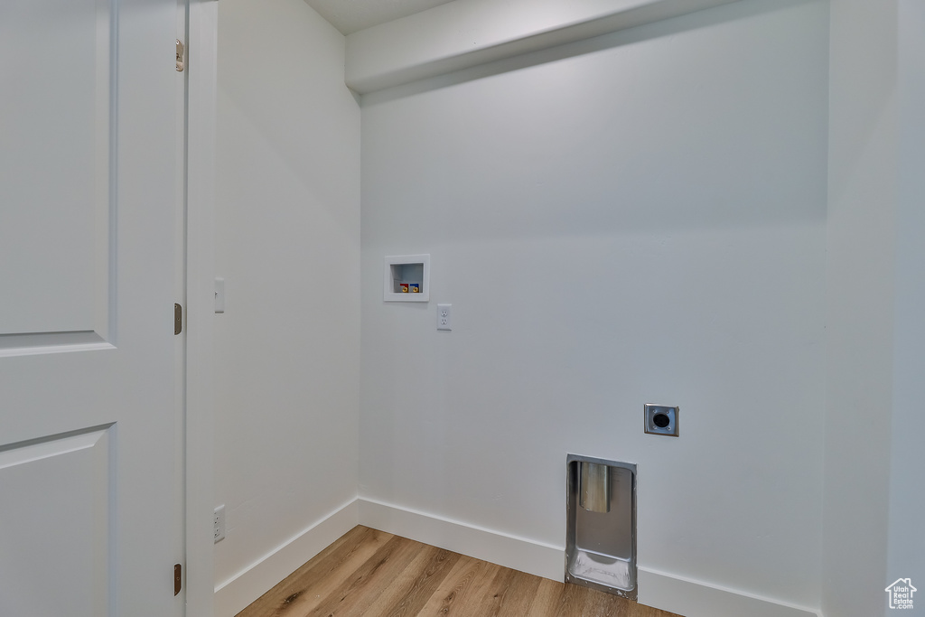 Laundry room with electric dryer hookup, washer hookup, and light hardwood / wood-style flooring