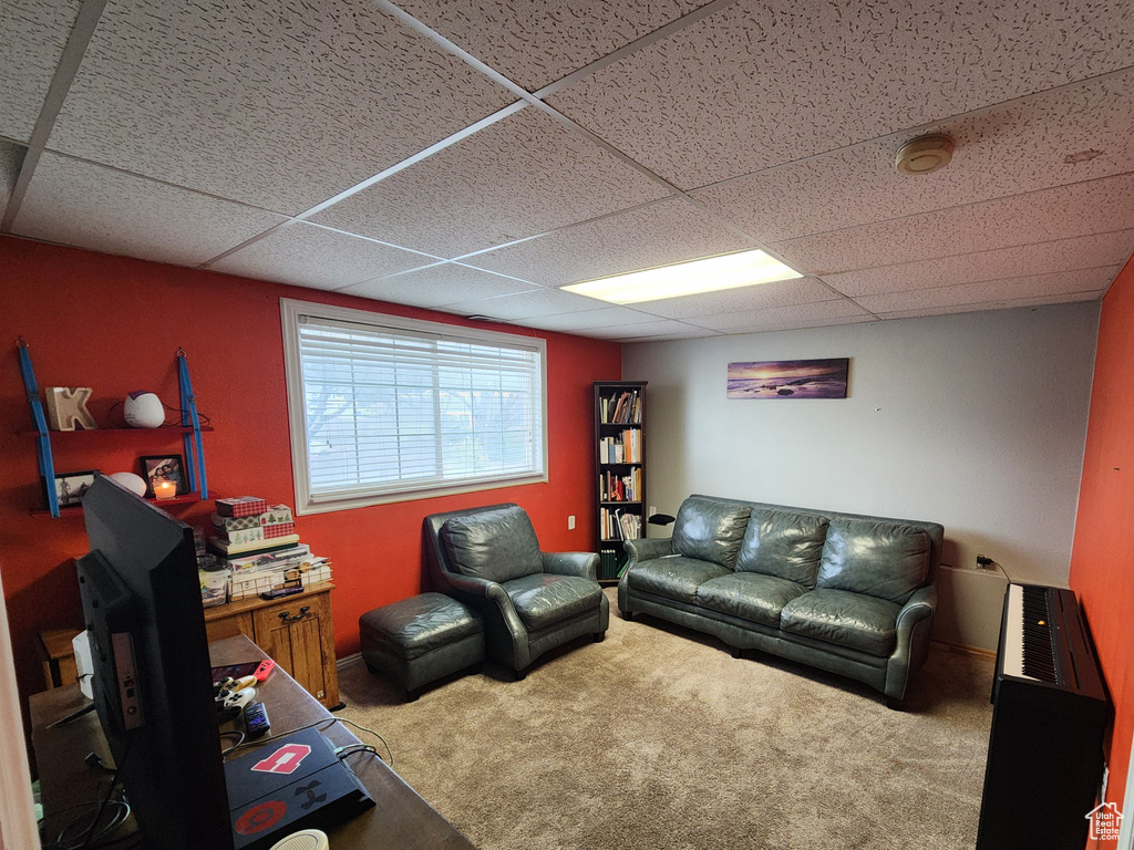 Carpeted living room featuring a drop ceiling