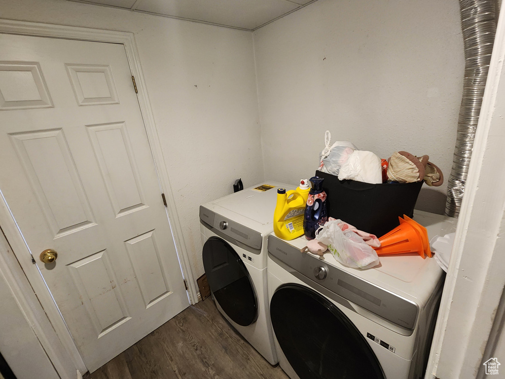 Washroom featuring washer and clothes dryer and dark hardwood / wood-style flooring