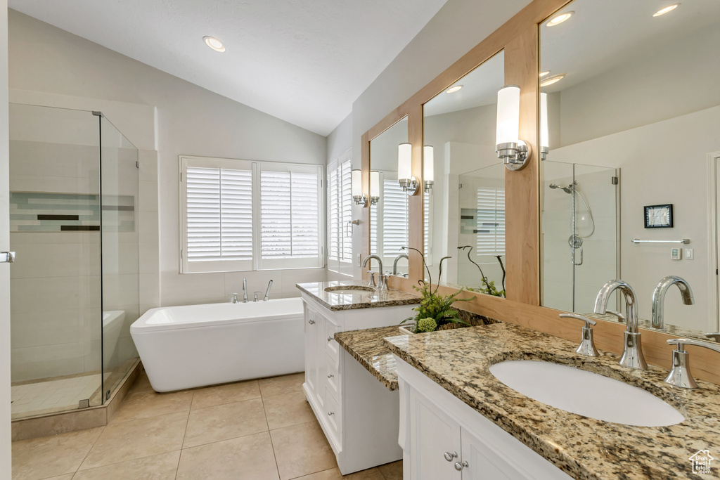 Bathroom with vanity, tile flooring, vaulted ceiling, and shower with separate bathtub