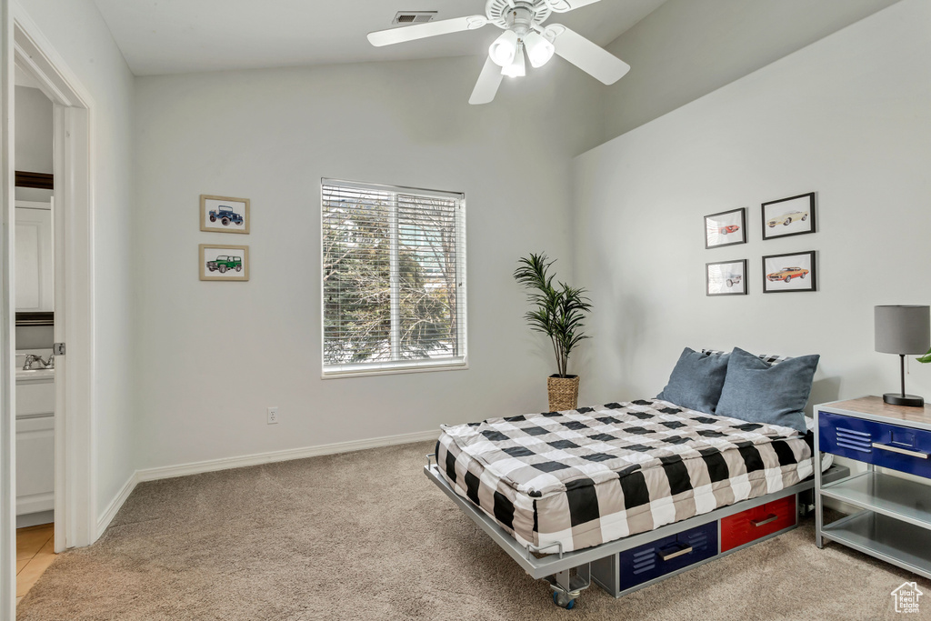 Carpeted bedroom with vaulted ceiling and ceiling fan