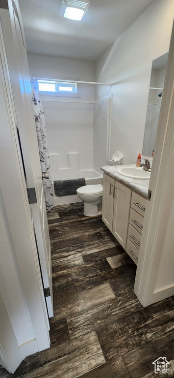 Full bathroom with hardwood / wood-style flooring, toilet, shower / bath combo, and vanity