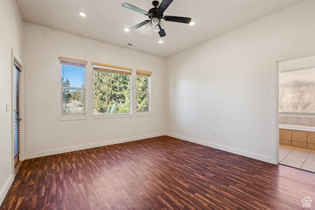 Unfurnished room featuring dark hardwood / wood-style flooring and ceiling fan