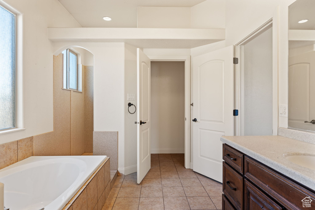 Bathroom featuring tile floors, a washtub, and vanity