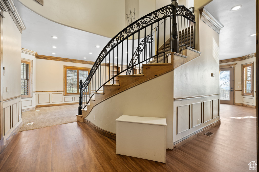 Stairway featuring light hardwood / wood-style flooring and crown molding