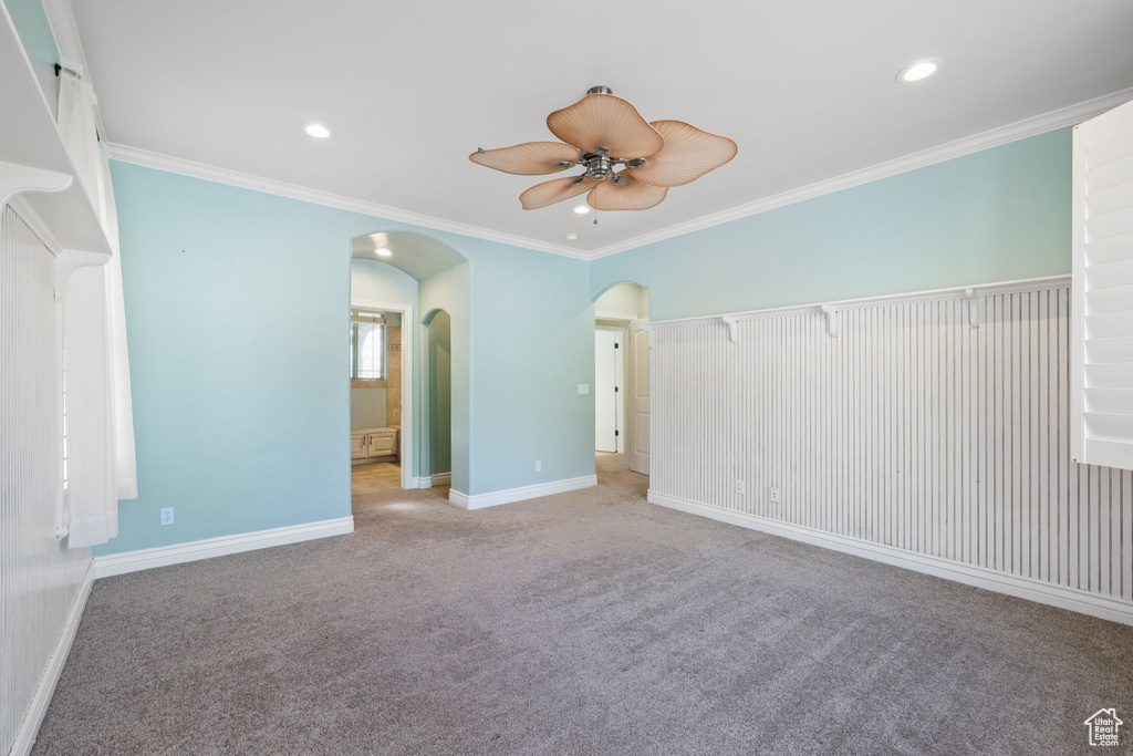 Interior space featuring light carpet, crown molding, and ceiling fan
