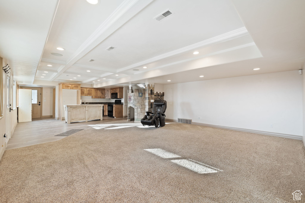 Workout room with a fireplace, light colored carpet, and coffered ceiling