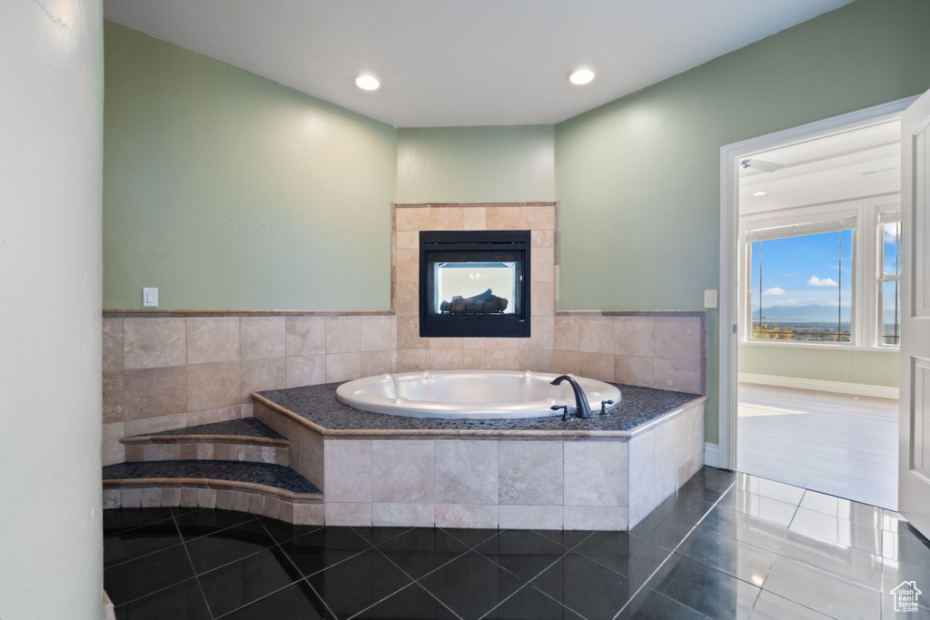 Bathroom with a tile fireplace, a relaxing tiled bath, and tile floors