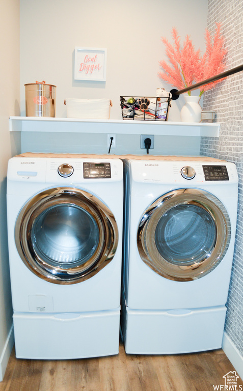 Laundry area with washing machine and dryer, hardwood / wood-style flooring, and electric dryer hookup