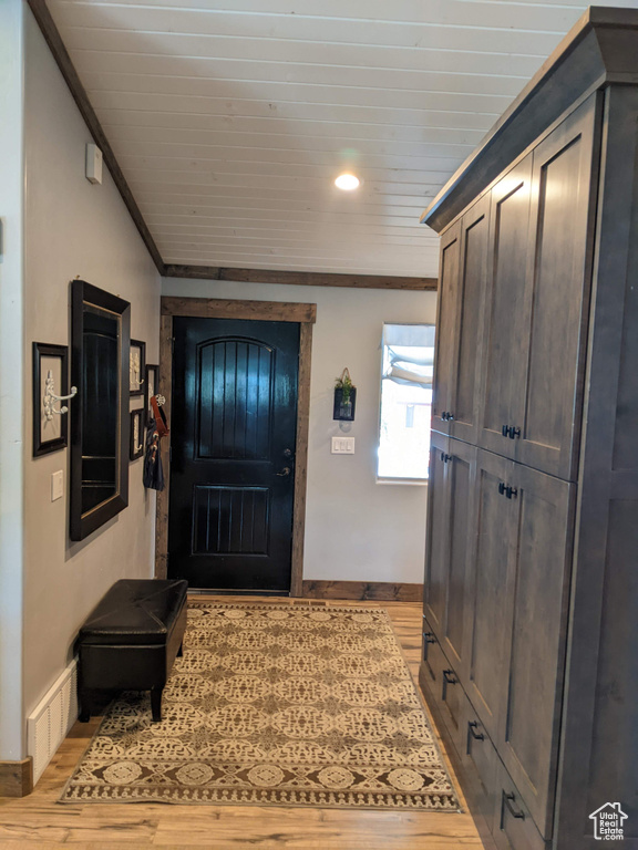 Foyer entrance featuring light hardwood / wood-style floors and ornamental molding