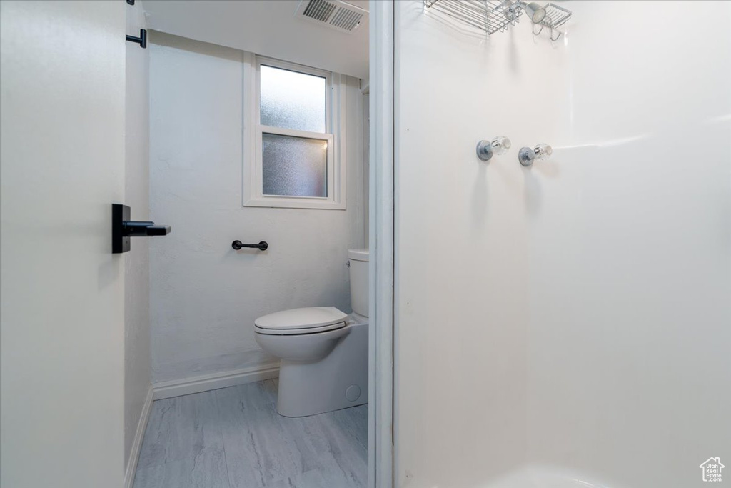 Bathroom featuring hardwood / wood-style flooring and toilet