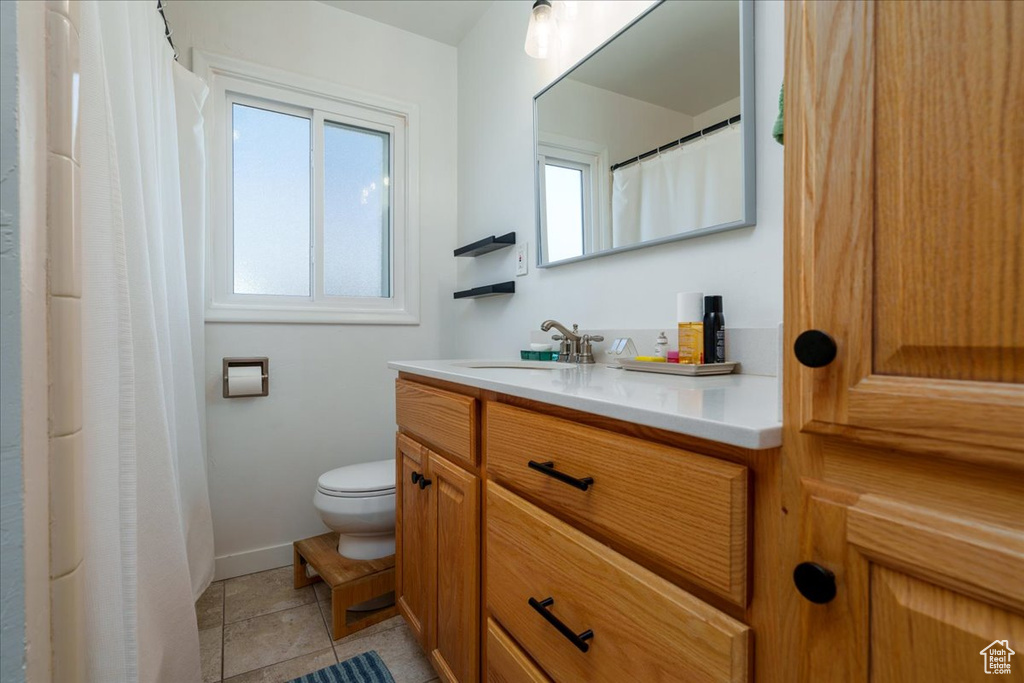 Bathroom with toilet, tile floors, and oversized vanity