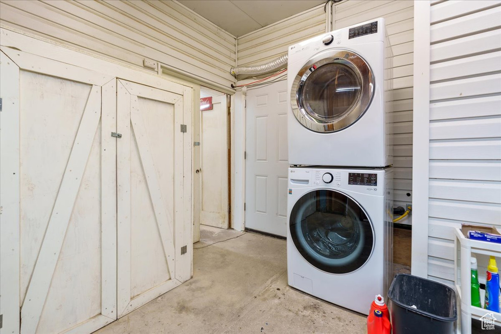 Clothes washing area featuring stacked washer and clothes dryer