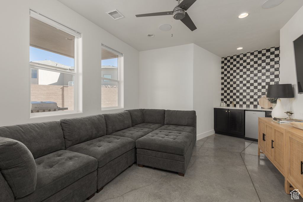 Living room featuring concrete floors and ceiling fan