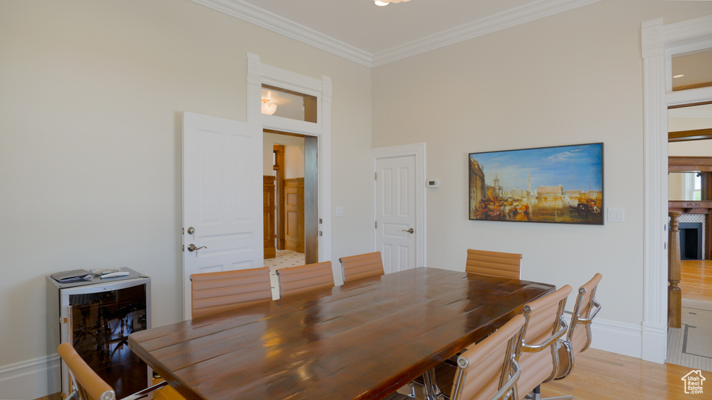 Dining room with crown molding and light hardwood / wood-style flooring