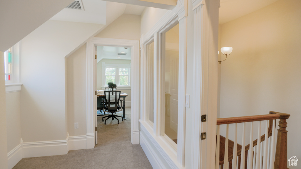 Hall featuring lofted ceiling and light colored carpet