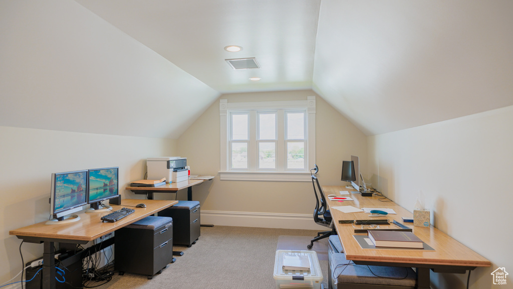 Office area with lofted ceiling and light colored carpet