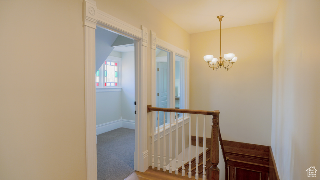 Hall with an inviting chandelier and carpet floors