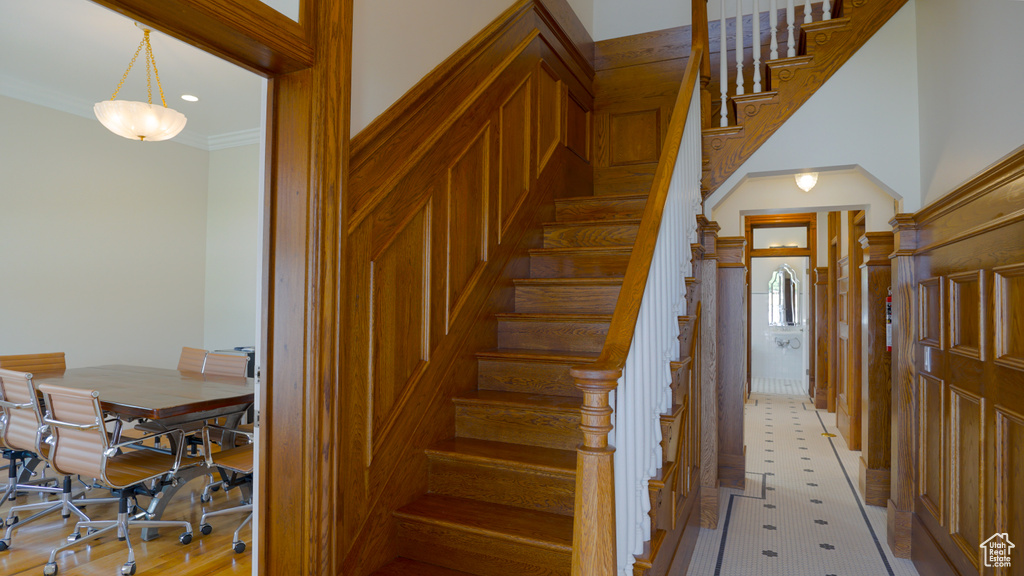 Stairs featuring ornamental molding and light tile floors