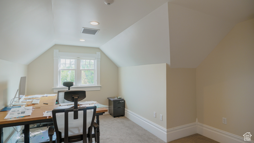 Carpeted office space with lofted ceiling