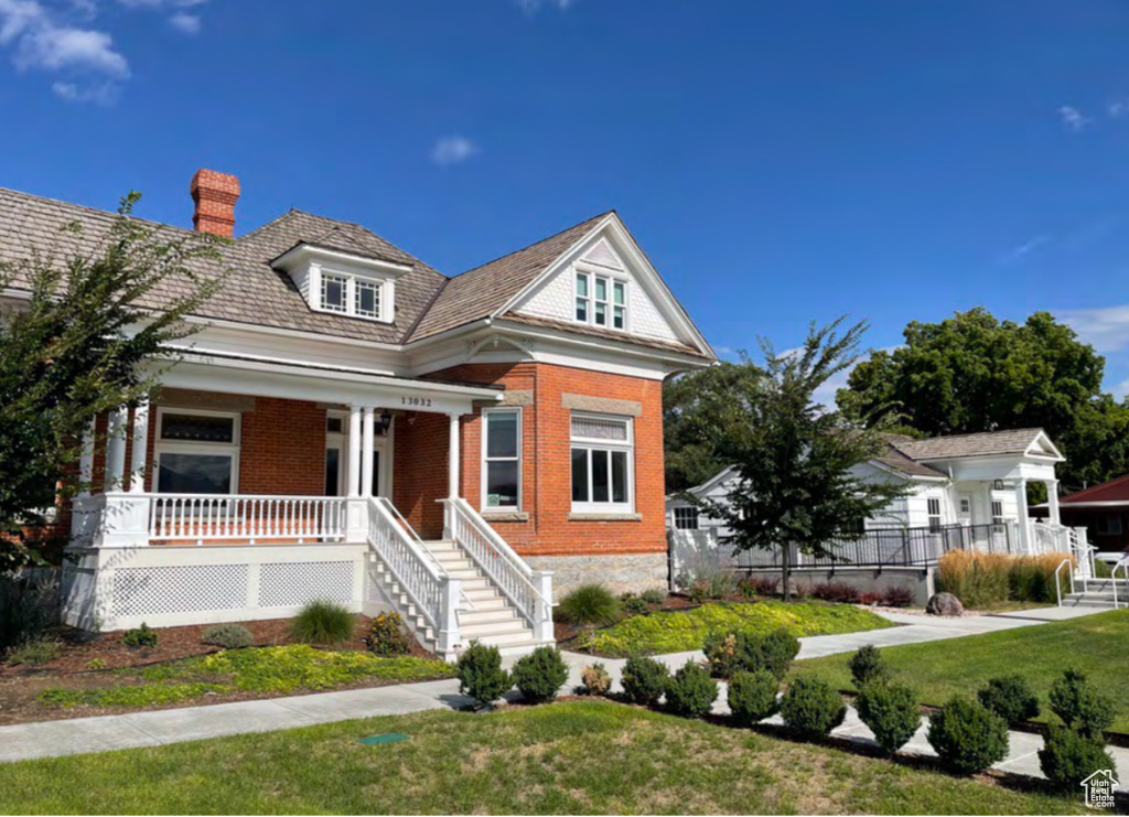 View of front facade with a front yard and a porch