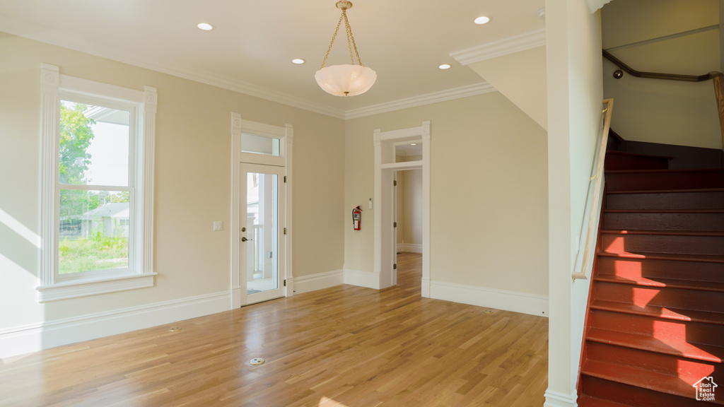 Entryway featuring crown molding, plenty of natural light, and light hardwood / wood-style floors