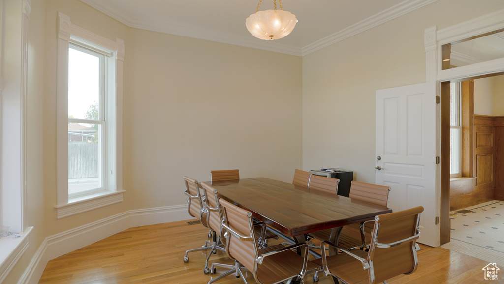 Tiled dining area featuring plenty of natural light and ornamental molding