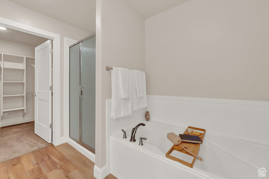 Bathroom featuring plus walk in shower and wood-type flooring