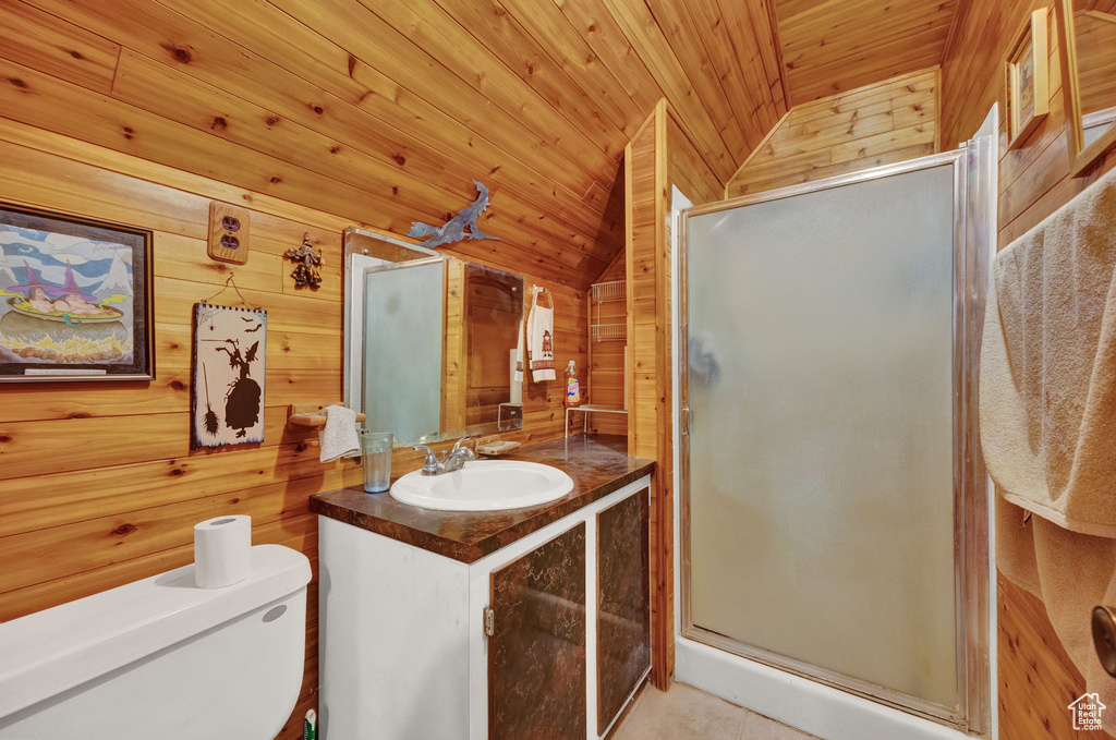 Bathroom featuring wood ceiling, lofted ceiling, wooden walls, and toilet