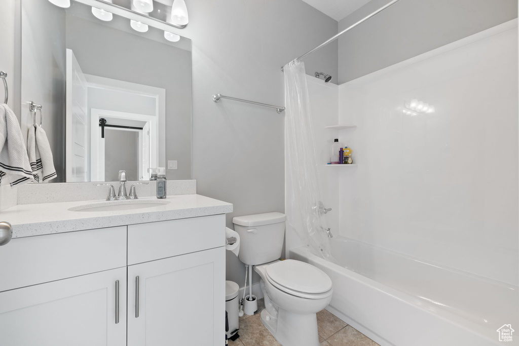 Full bathroom featuring tile floors, shower / bath combo, vanity, and toilet