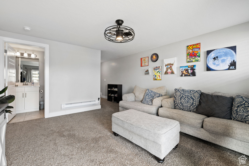 Carpeted living room with ceiling fan and a baseboard radiator
