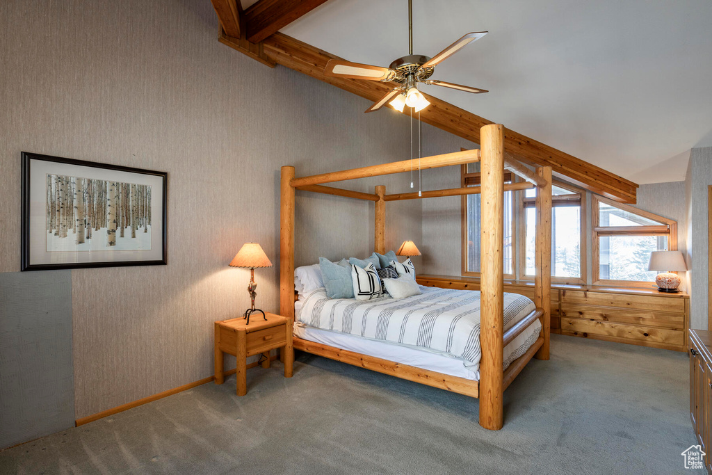 Carpeted bedroom with beam ceiling and ceiling fan