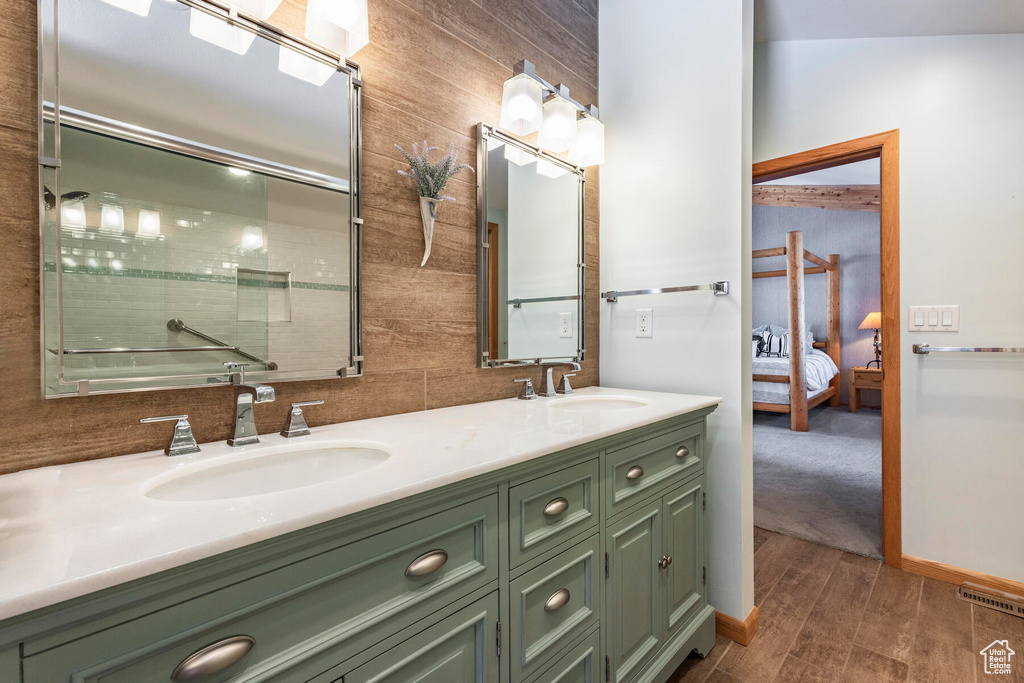 Bathroom with lofted ceiling, double sink, hardwood / wood-style floors, and large vanity