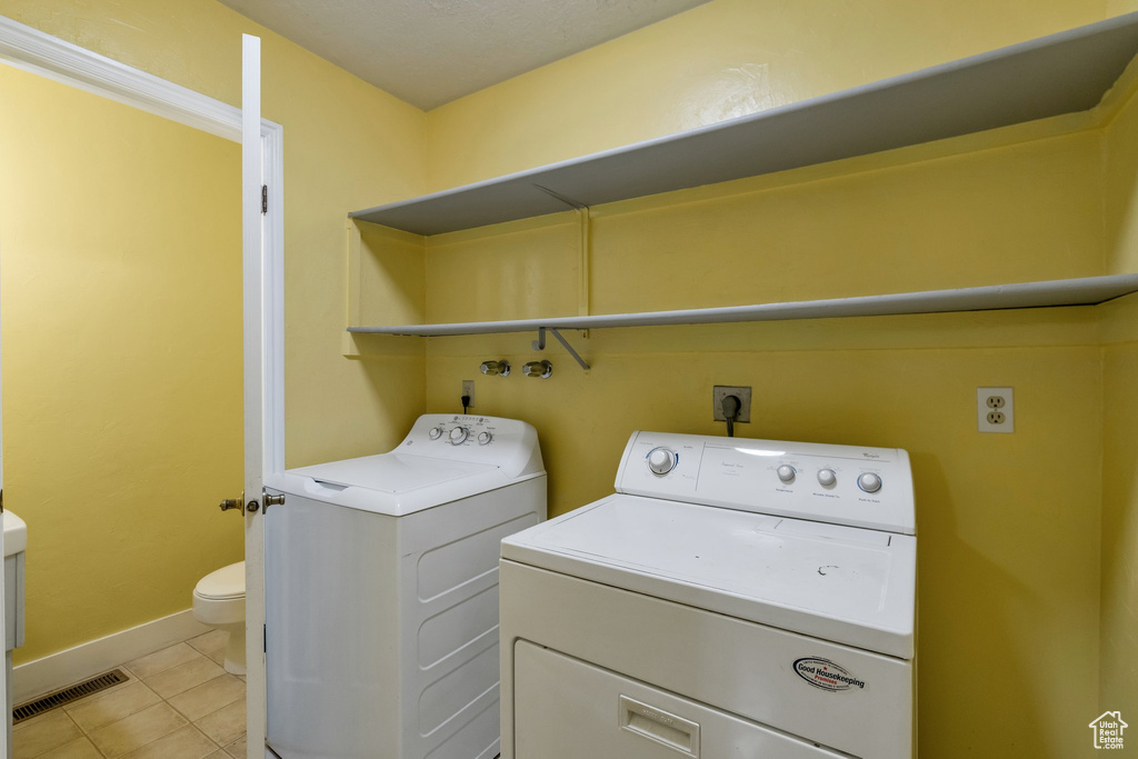 Laundry area with independent washer and dryer, hookup for an electric dryer, and light tile floors