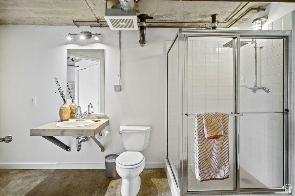 Bathroom featuring walk in shower, sink, and toilet