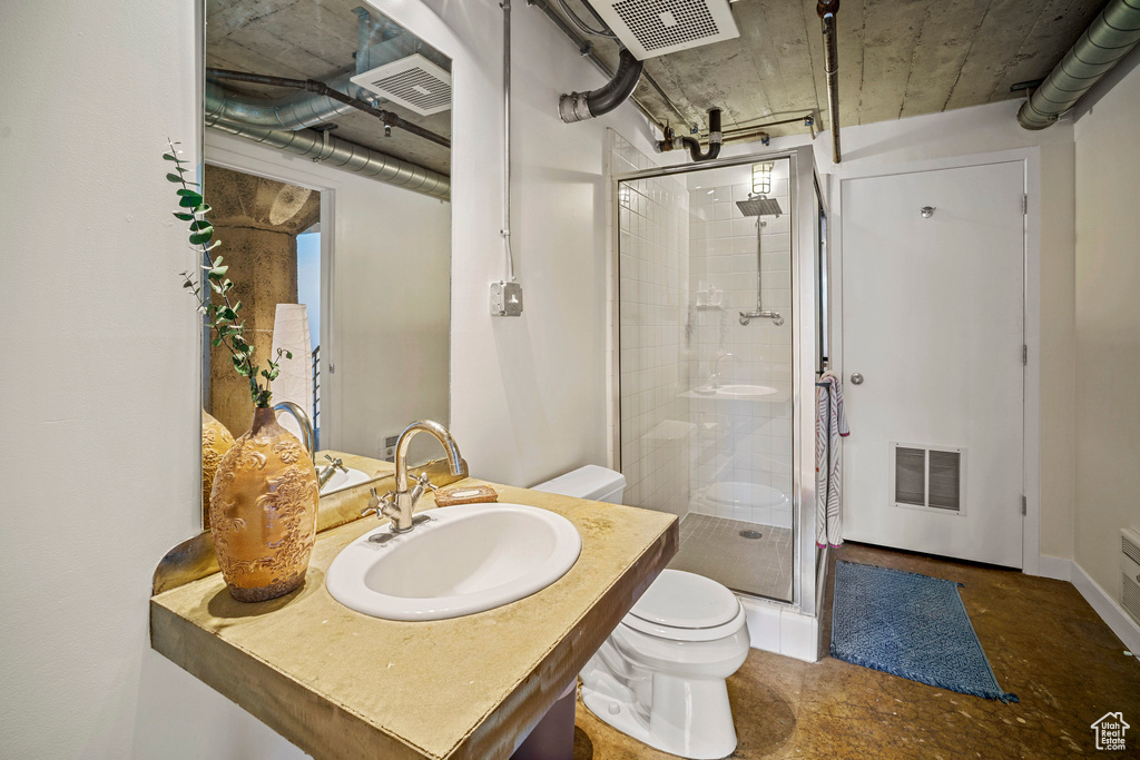 Bathroom featuring an enclosed shower, concrete floors, toilet, and oversized vanity