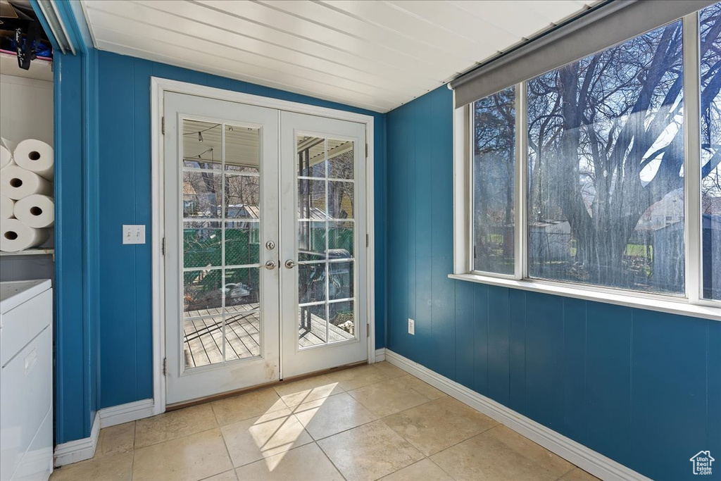 Doorway with french doors, washer / clothes dryer, and light tile floors