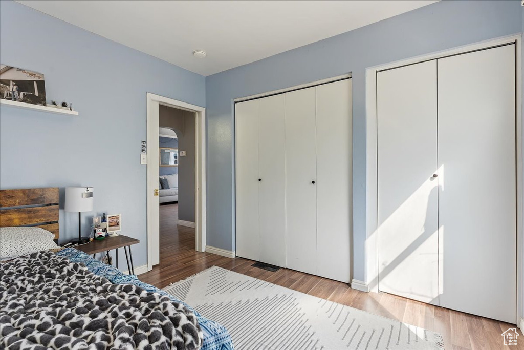 Bedroom featuring light hardwood / wood-style floors and two closets