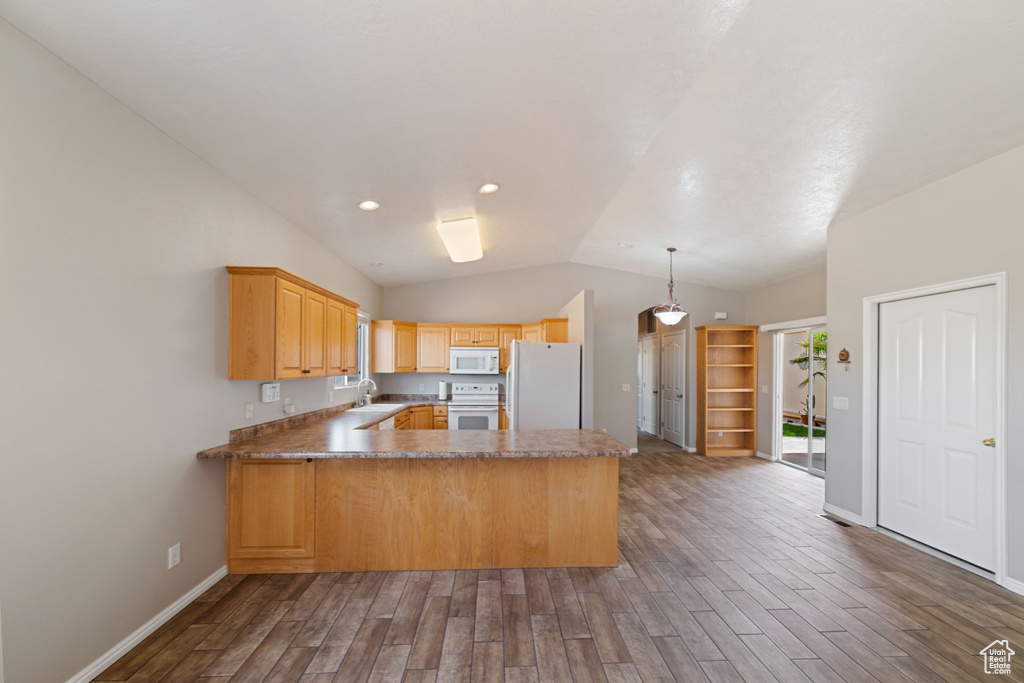 Kitchen featuring wood-type flooring, kitchen peninsula, decorative light fixtures, lofted ceiling, and white appliances