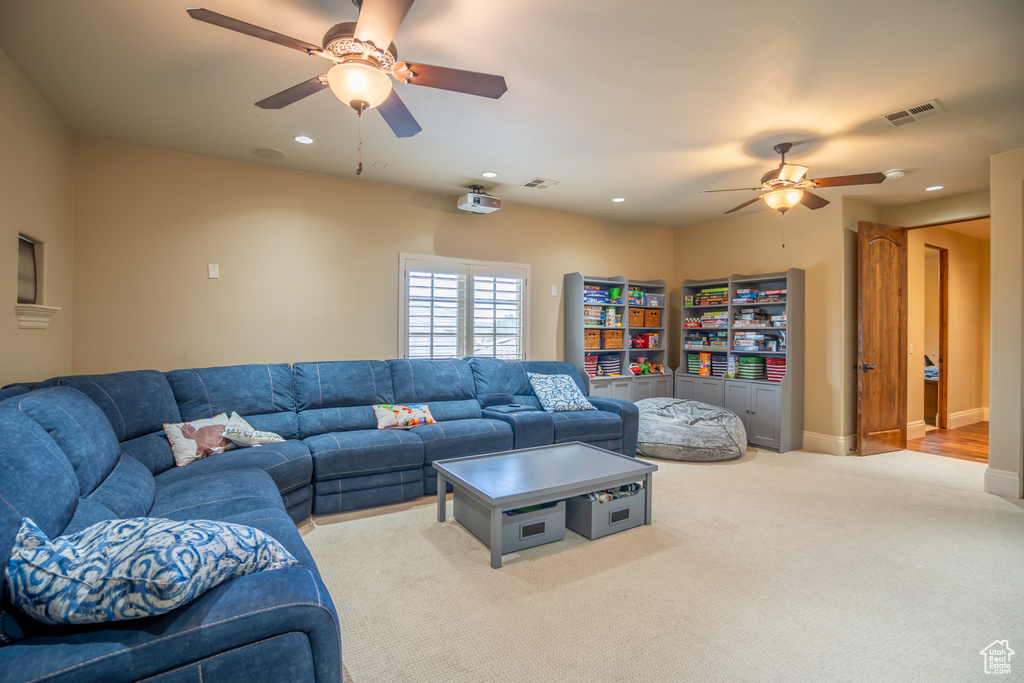 Carpeted living room with ceiling fan