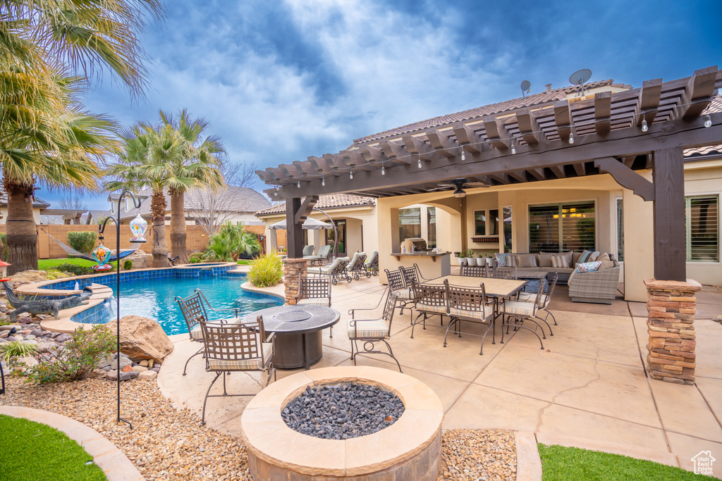 View of pool featuring ceiling fan, an outdoor living space with a fire pit, a patio area, and a pergola