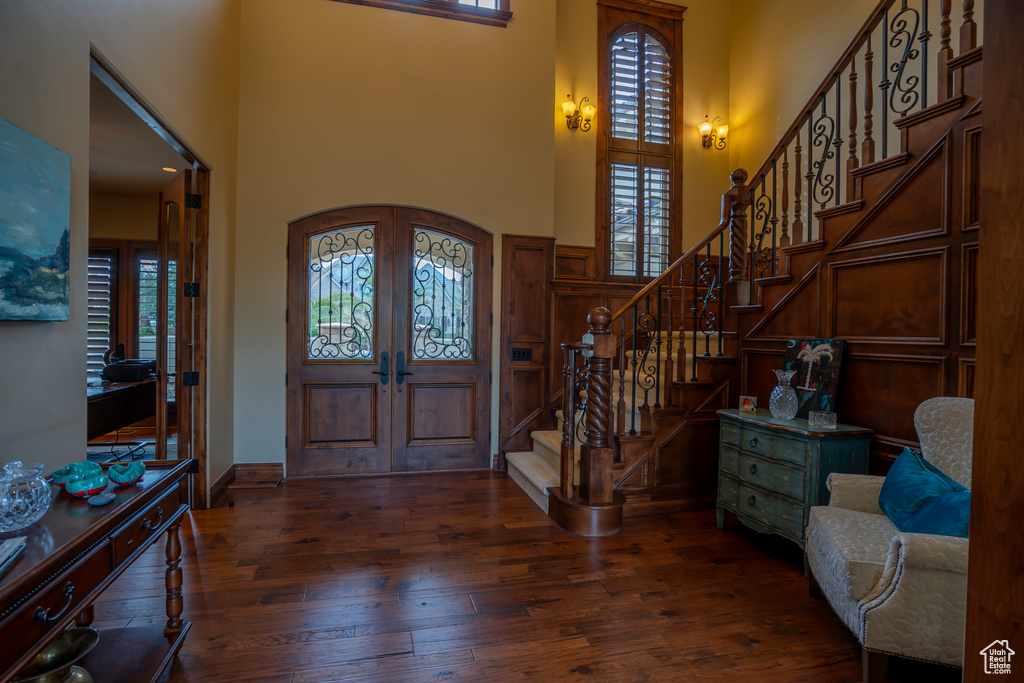 Entrance foyer featuring a high ceiling, dark wood-type flooring, and french doors