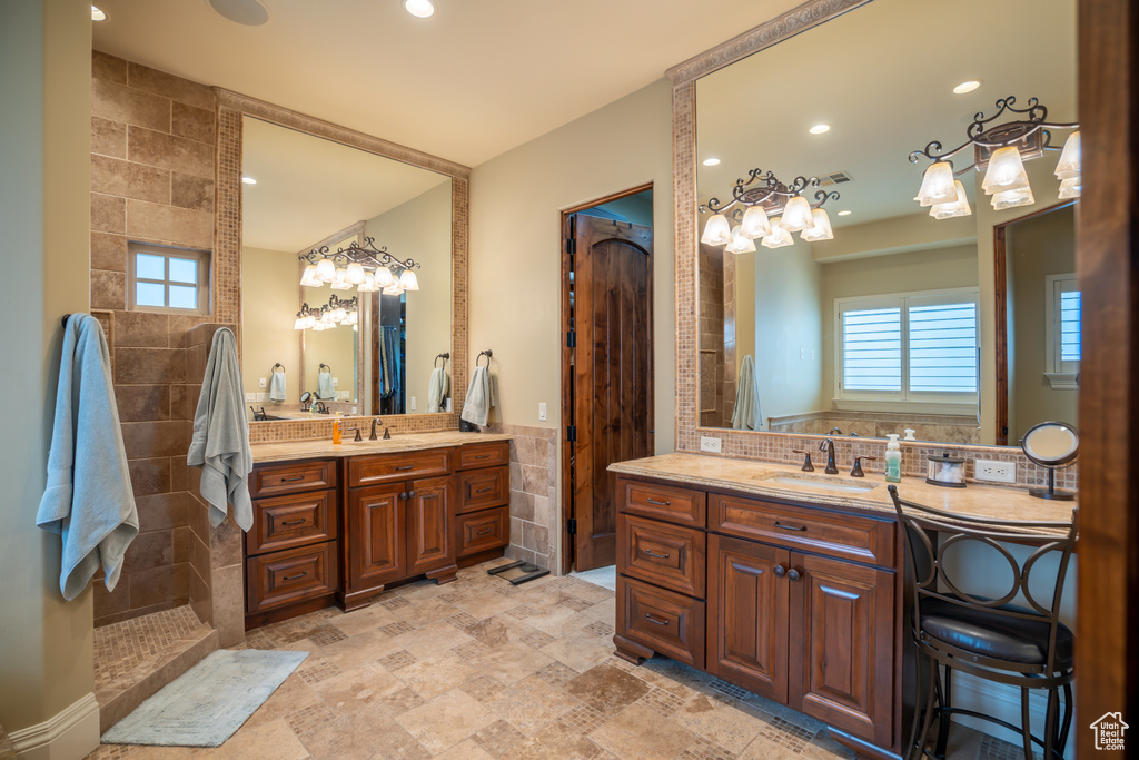 Bathroom with tile floors, walk in shower, a wealth of natural light, and double vanity